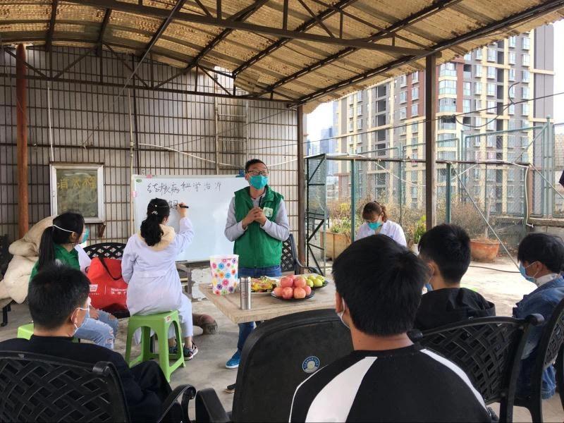 Xu patiently showing the TB patient the right way of putting on the mask and sharing related knowledge on the disease prevention and control.